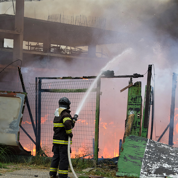 Fireman extinguishing a business fire at a premises.