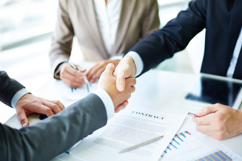 shaking hands in business contract meeting highlights business risk