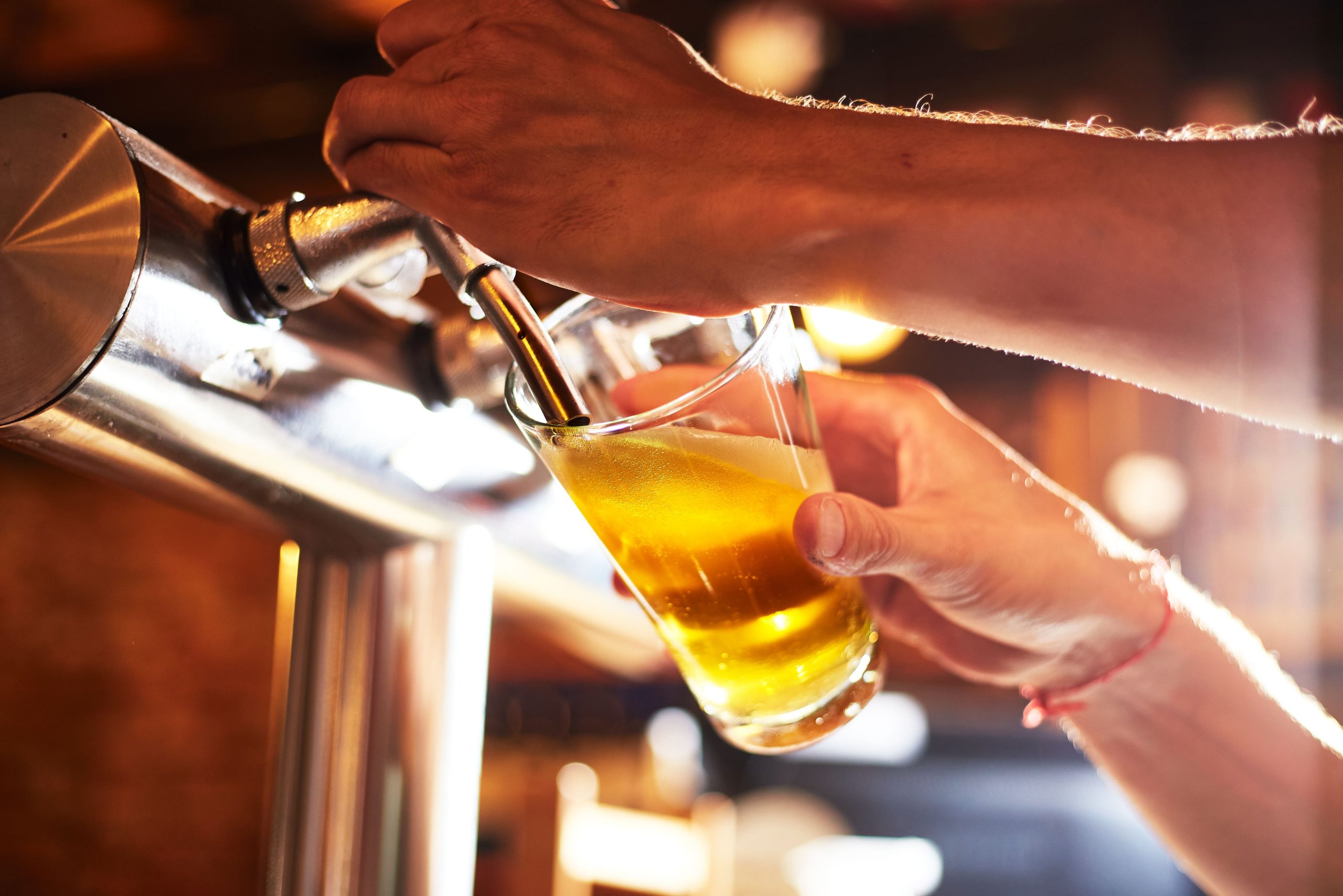 Bar tender pouring beer from a tap
